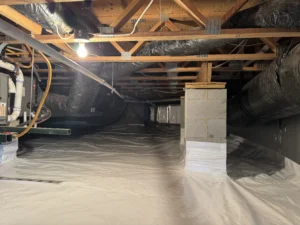 A bright, sealed crawlspace with a smooth vapor barrier, insulated walls, and proper ventilation, showcasing EcoCrawls’ completed encapsulation project.
