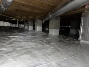Showing the crawlspace with the vapor barrier installed.