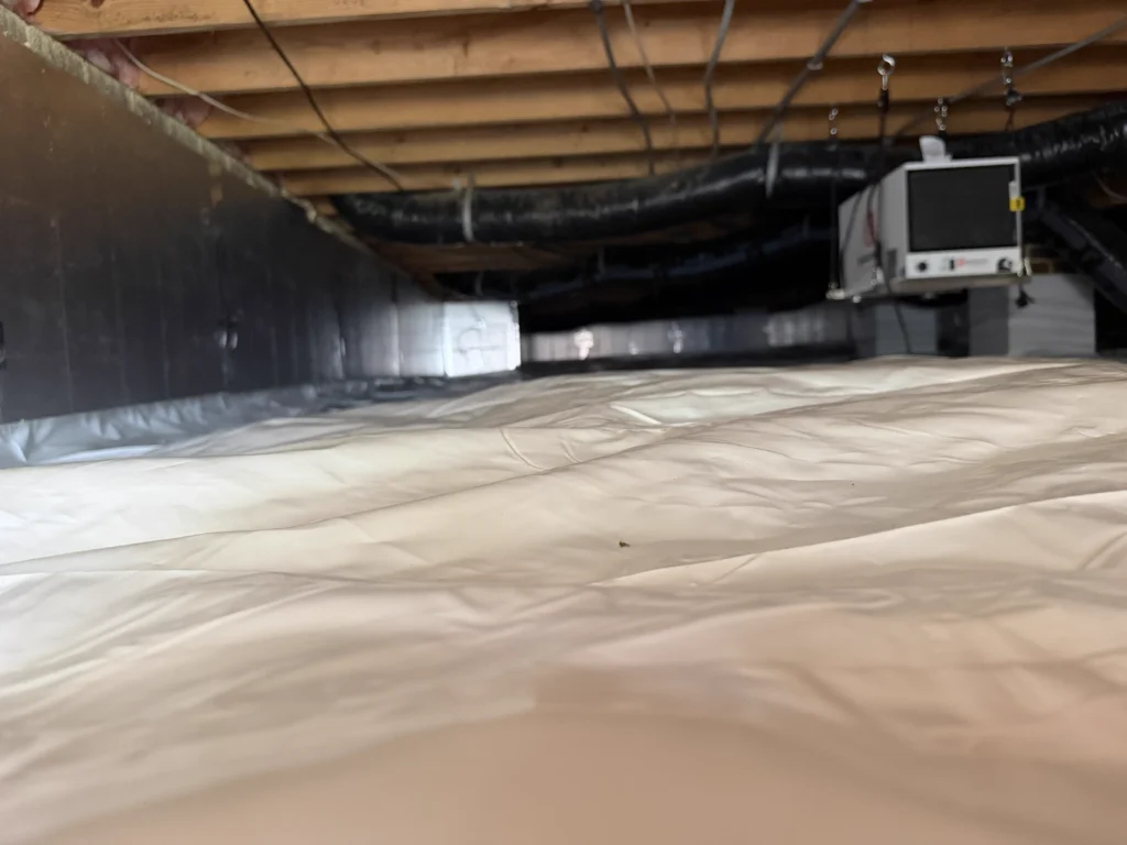 Finished crawlspace in Chapel Hill featuring full encapsulation with a sealed vapor barrier, interior French drain system, sump pump basin, dehumidifier installation, and completed mold remediation for long-term moisture control.