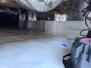 Encapsulated crawlspace with a sealed vapor barrier covering the ground and foundation walls beneath a historic home.